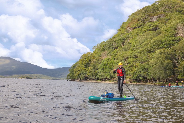 a man riding on the back of a boat in a body of water